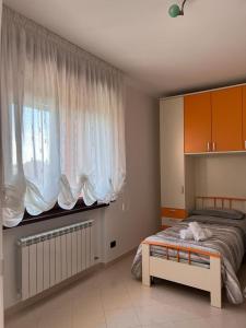 um quarto com uma cama e uma grande janela em B&B Nausica em Ripalimosani