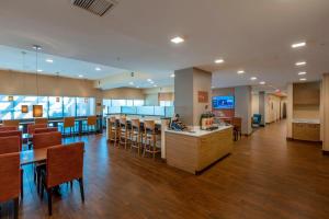 ホプキンスビルにあるTownePlace Suites by Marriott Hopkinsvilleのロビーにはバーと椅子のあるカフェテリアがあります。
