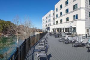 una terrazza con sedie e un edificio accanto all'acqua di Fairfield Inn & Suites Seneca Clemson Univ Area a Seneca