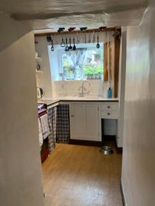 een keuken met een wastafel en een raam bij Crosse Chance Cottage - Idyllic, beautiful, traditional cottage to love - Wood burner in Taddington