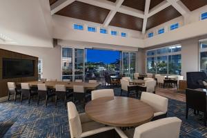 a dining room with tables and chairs and windows at TownePlace Suites by Marriott San Diego Airport/Liberty Station in San Diego