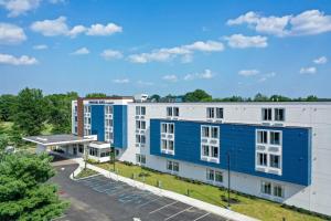 un bâtiment bleu et blanc avec un parking dans l'établissement SpringHill Suites by Marriott Woodbridge, à Woodbridge