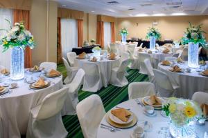 una sala de banquetes con mesas blancas y sillas blancas en Fairfield Inn & Suites Cartersville, en Cartersville