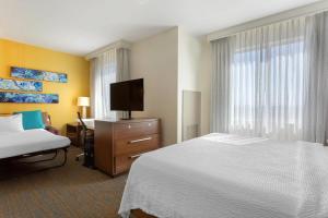 a hotel room with a bed and a desk and a television at Residence Inn by Marriott Secaucus Meadowlands in Secaucus
