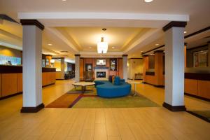 uma grande sala de estar com um sofá azul e colunas em Fairfield Inn & Suites by Marriott Cordele em Cordele