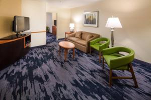 uma sala de estar com um sofá e cadeiras e uma televisão em Fairfield Inn and Suites by Marriott South Boston em South Boston
