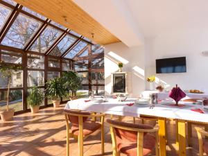 a dining room with a table and chairs and windows at Villa Tatry Stola in Vyšné Hágy