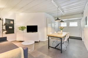 een woonkamer met een tafel en een tv in een kamer bij Zeeuwse Kustbunker in Groede