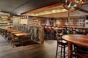 a restaurant with wooden tables and chairs and a bar at Atlanta Airport Marriott in Atlanta