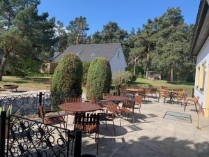 an outdoor patio with tables and chairs and trees at Ferienpark Buntspecht Apartment A in Pruchten
