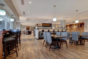 門羅的住宿－TownePlace Suites by Marriott Monroe，一间带桌椅和钢琴的餐厅