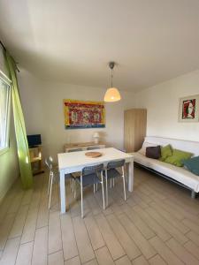 Il Pinolo 2 في مارينا دي سيسينا: غرفة معيشة مع طاولة وكراسي وأريكة