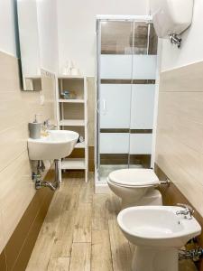 een badkamer met 2 wastafels, een toilet en een douche bij Big Fish Alghero Guesthouse in Alghero
