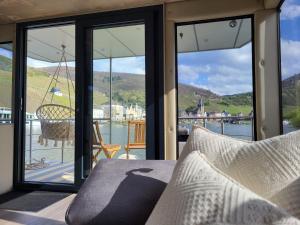a room with a balcony with views of the water at KL Moselboote - Hausboot Neptun in Bernkastel-Kues