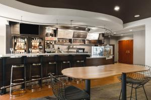 un bar con mesa de madera y sillas en Courtyard El Paso Airport, en El Paso