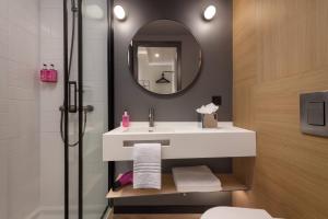 a bathroom with a sink and a shower with a mirror at Moxy Lisboa Oriente in Lisbon