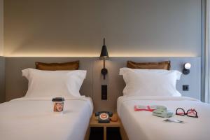 two beds sitting next to each other in a hotel room at Moxy Lisboa Oriente in Lisbon