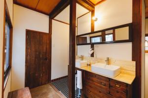 La salle de bains est pourvue de 2 lavabos et d'un miroir. dans l'établissement Couch Potato Hostel - Vacation STAY 88241, à Matsumoto