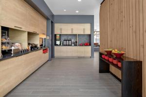 a kitchen with wooden cabinets and a counter top at TownePlace Suites by Marriott Loveland Fort Collins in Loveland