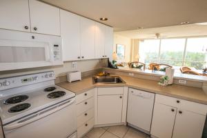 eine Küche mit weißen Schränken und einem weißen Herd mit Backofen in der Unterkunft Lovers Key Resort 308 in Fort Myers Beach
