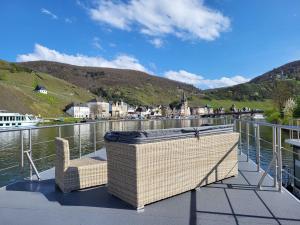a balcony with a chair and a body of water at KL Moselboote - Hausboot Neptun in Bernkastel-Kues