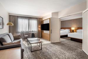 una camera d'albergo con divano e letto di Sheraton Suites Wilmington Downtown a Wilmington