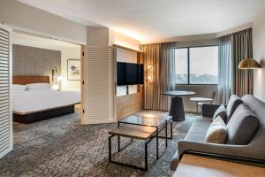 Una habitación de hotel con una cama, un sofá y una mesa. en Sheraton Suites Wilmington Downtown, en Wilmington