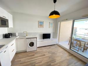 una cucina con lavatrice e lavandino di 06AI - Beau studio rénové - vue mer et piscine a Vallauris