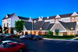 un grand bâtiment avec des voitures garées dans un parking dans l'établissement Residence Inn by Marriott Somerset, à Somerset