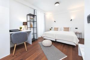 a white bedroom with a bed and a desk and a chair at Modern and cozy apartments Salt & Pepper in heart of Rovinj in Rovinj