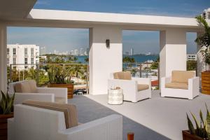a balcony with white chairs and a view of the ocean at Residence Inn by Marriott Miami Beach South Beach in Miami Beach