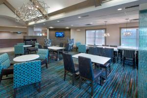 a dining room with tables and chairs and a tv at Residence Inn by Marriott Somerset in Somerset