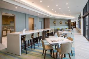 a restaurant with tables and chairs and a kitchen at Residence Inn by Marriott Miami Beach South Beach in Miami Beach