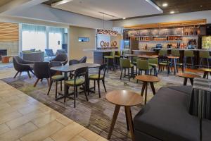 a restaurant with tables and chairs and a bar at Courtyard by Marriott Eugene Springfield in Springfield