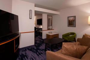 um quarto de hotel com um sofá, uma mesa e uma televisão em Fairfield Inn & Suites by Marriott Venice em Venice