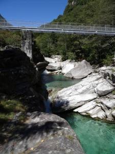 un pont sur une rivière avec un pont sur celle-ci dans l'établissement Rustico Cà Laura, à Brione