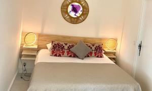 Schlafzimmer mit einem Bett mit roten Kissen und einem Spiegel in der Unterkunft Les Lodges de Saint Cassien 2 in Montauroux