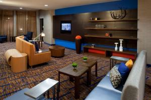 a hotel lobby with couches and a tv at Courtyard Texarkana in Texarkana
