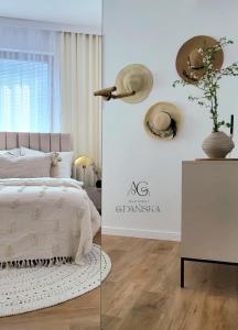 a bedroom with a white bed and a white wall at Apartament Gdańska in Gdańsk