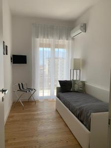 ein weißes Zimmer mit einem Bett und einem Fenster in der Unterkunft Magister Guest House in Pompei
