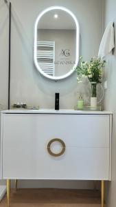 a white dressing table with a mirror on the wall at Apartament Gdańska in Gdańsk
