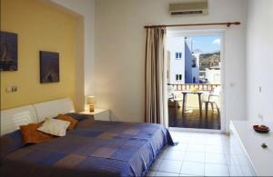 a bedroom with a bed and a view of a balcony at Morpheas Apartments in Plakias