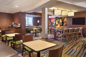 Fairfield Inn & Suites by Marriott Barrie في باري: مطعم بطاولات وكراسي وبار