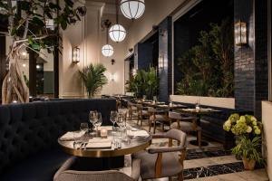 un restaurante con mesas, sillas y luces en The Dalmar, Fort Lauderdale, a Tribute Portfolio Hotel en Fort Lauderdale