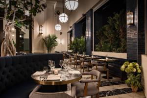 a restaurant with tables and chairs and lights at The Dalmar, Fort Lauderdale, a Tribute Portfolio Hotel in Fort Lauderdale