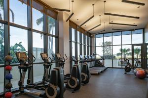 un gimnasio con cintas de correr y elípticas en una habitación con ventanas en The Dalmar, Fort Lauderdale, a Tribute Portfolio Hotel en Fort Lauderdale