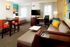 a hotel room with a couch and a bed and a desk at Residence Inn by Marriott Orlando Lake Nona in Orlando