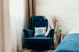 a blue chair with a pillow in a bedroom at Apartament Talaso in Puck