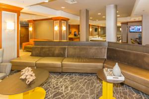 SpringHill Suites by Marriott Tampa Westshore في تامبا: غرفة معيشة مع أريكة وطاولات كبيرة