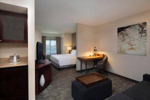 SpringHill Suites by Marriott Tampa Westshore في تامبا: غرفة في الفندق مع سرير ومكتب